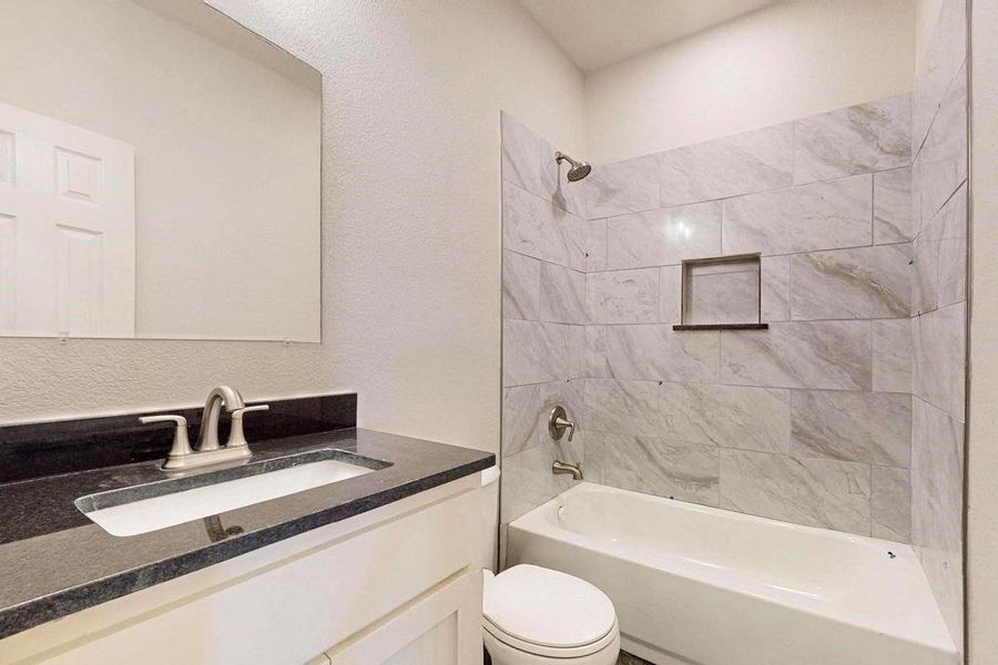 Bathroom with toilet, washtub / shower combination, and vanity