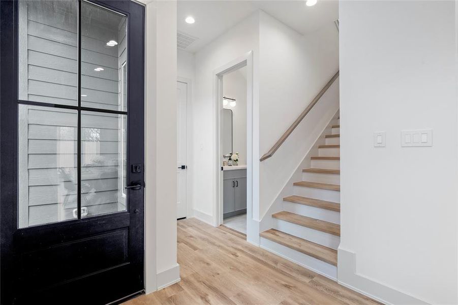 A sleek and space-efficient half bath conveniently tucked under the staircase, featuring modern finishes and designer touches.