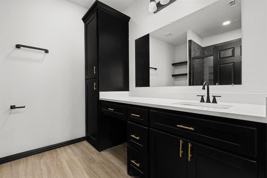 Bathroom with hardwood / wood-style floors, vanity, and a shower with shower door