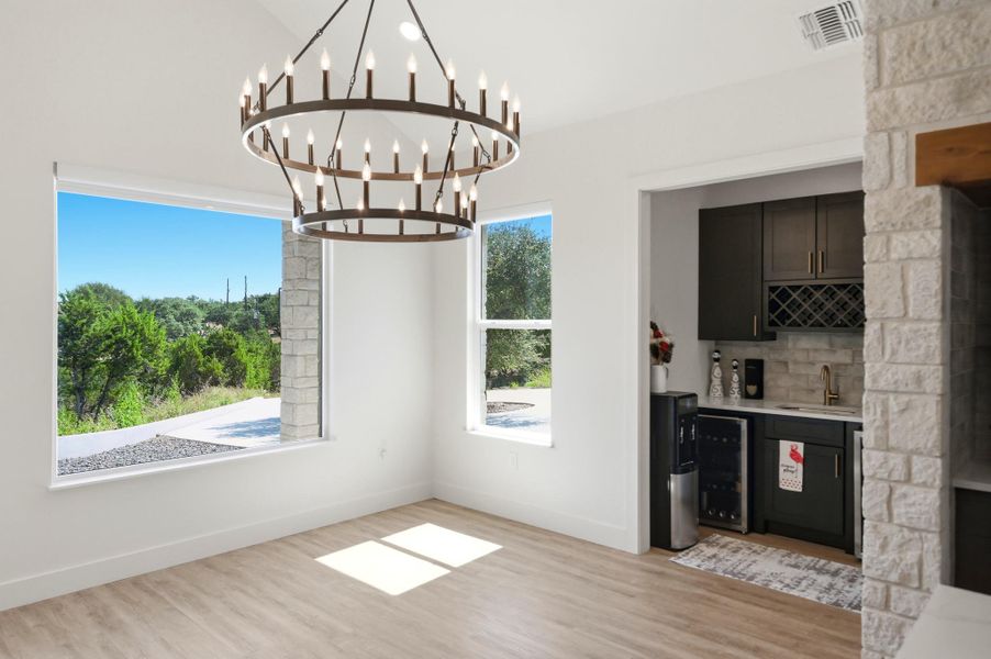 Gleaming hardwood floors and a statement chandelier anchor this airy dining space.