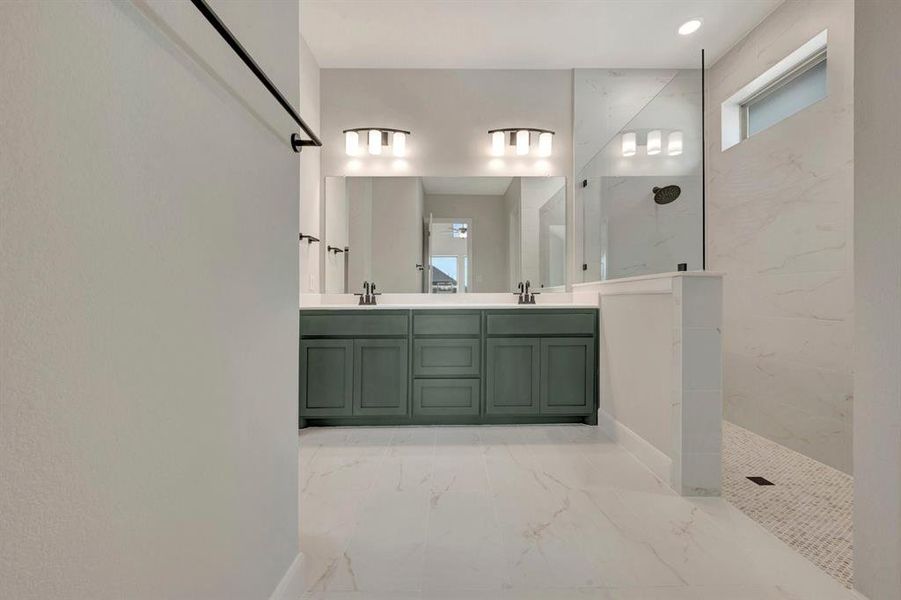 Modern bathroom featuring a double vanity with green cabinetry, white countertops, and dual mirrors with integrated lighting