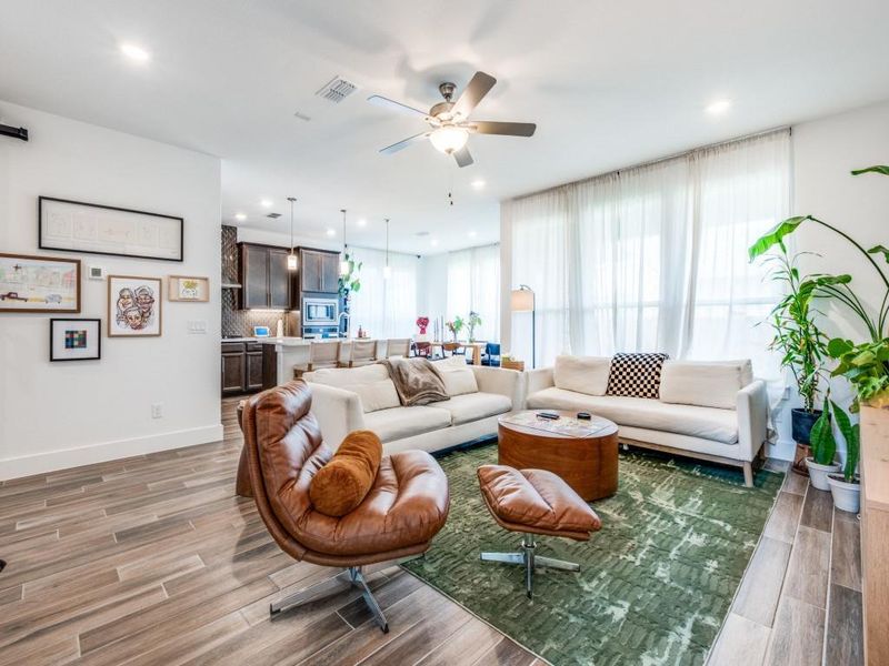 Living room with light wood finished floors, a ceiling fan, and recessed lighting