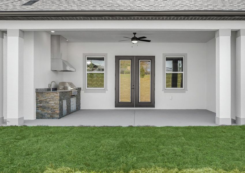 The covered outdoor living area includes a grill.
