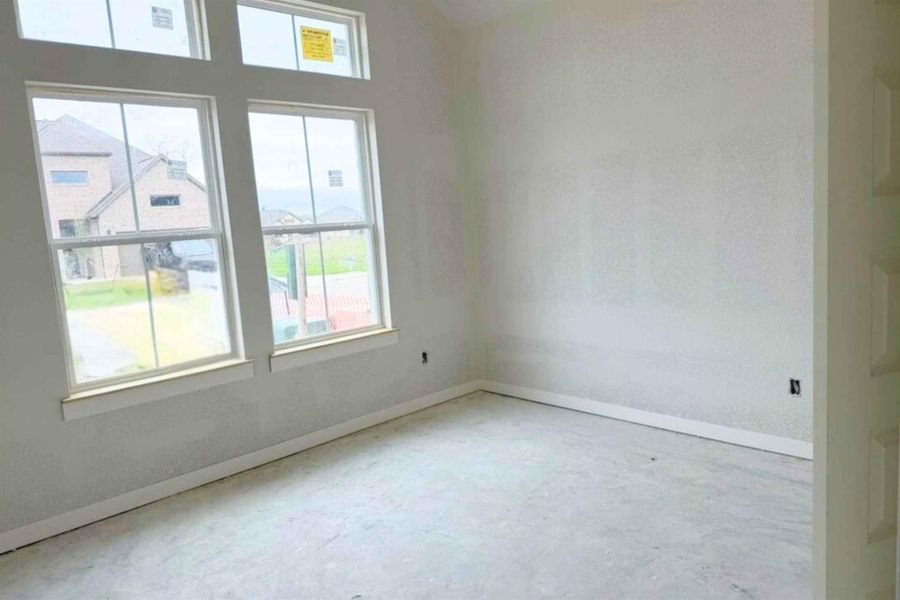 Empty room featuring concrete floors and baseboards