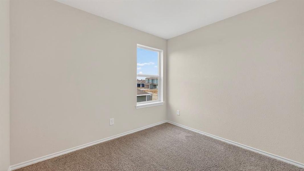 Compact room featuring a single window, neutral wall paint, and gray carpet flooring