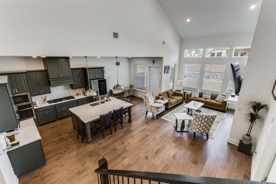 Living room with dark wood finished floors, vaulted ceiling, and recessed lighting