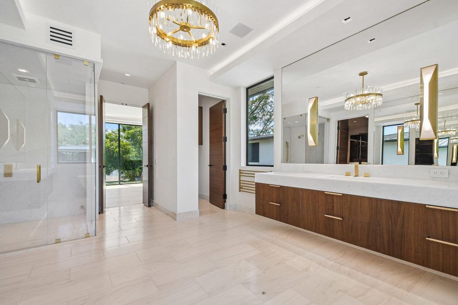 Clean lines and warm wood vanities elevate this light-filled modern bathroom space. Clean lines and warm wood vanities elevate this light-filled modern bathroom space.