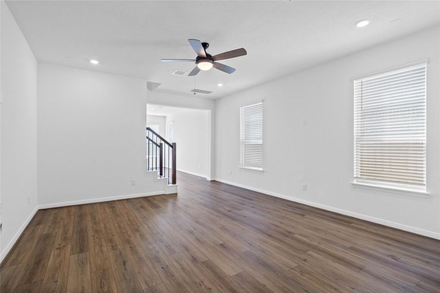 Bring family and friends together in this beautiful Great Room! It features high ceilings, ceiling fan with lighting, recessed lighting, custom paint, stunning vinyl plank flooring, and large windows that fill the space with natural light all day long.