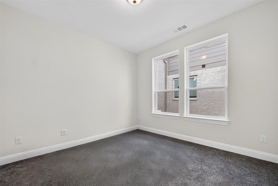 Unfurnished room with dark carpet and baseboards Unfurnished room with dark carpet and baseboards