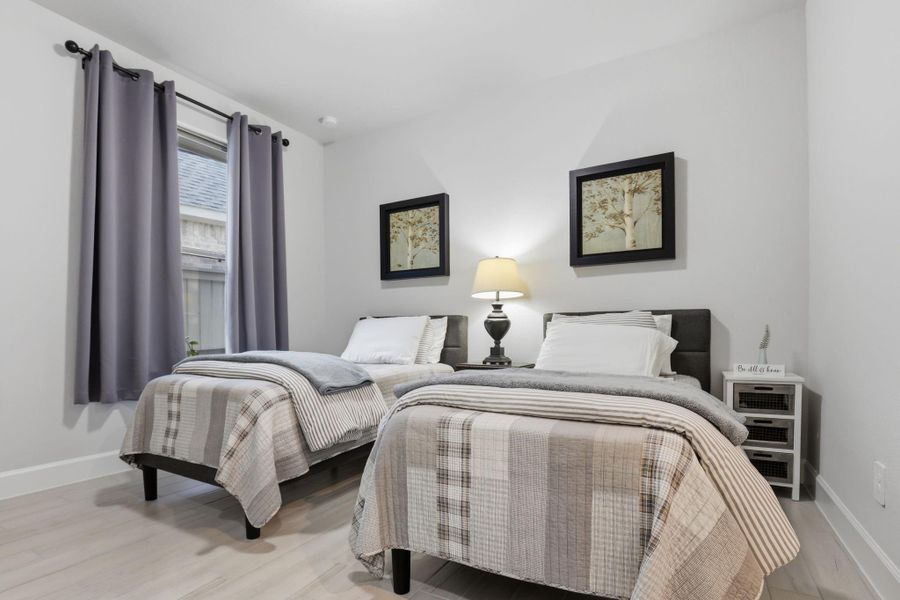 Generously sized secondary bedrooms feature ample natural light and beautiful wood-look plank flooring.