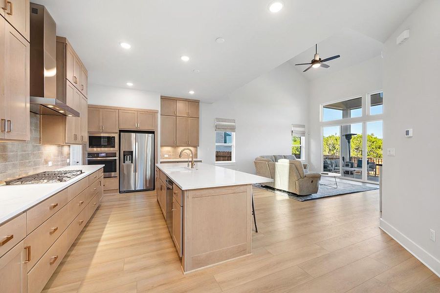 Gleaming wood floors anchor an airy kitchen open directly to a soaring living space.