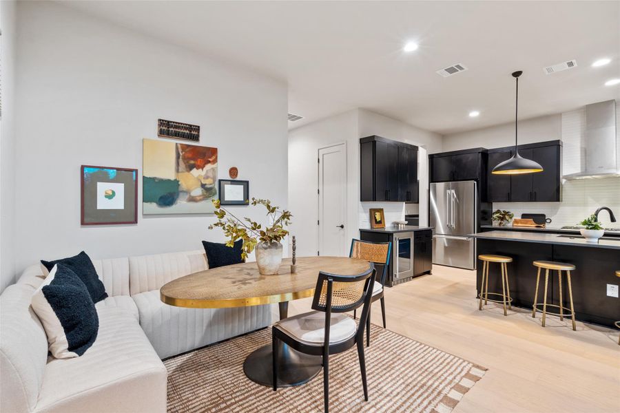A well-lit, open-concept kitchen and dining area features sleek cabinetry and light wood flooring. A well-lit, open-concept kitchen and dining area features sleek cabinetry and light wood flooring.