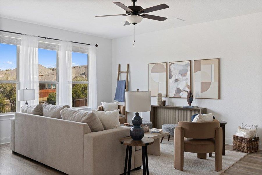 Living room with light wood-style flooring and a ceiling fan Living room with light wood-style flooring and a ceiling fan
