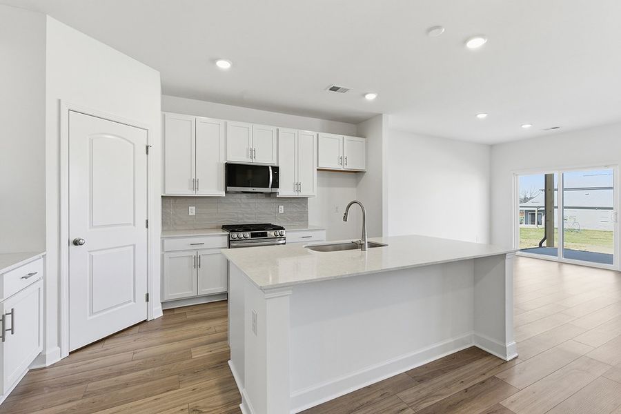 A kitchen with white cabinets.