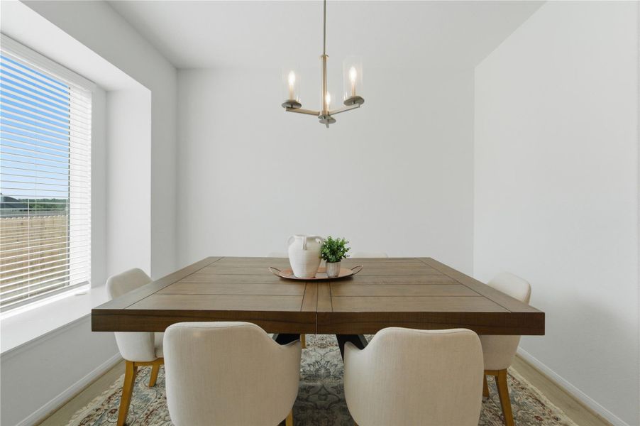 A graceful chandelier illuminates the generously sized dining table, offering a prime setting for meals. A graceful chandelier illuminates the generously sized dining table, offering a prime setting for meals.