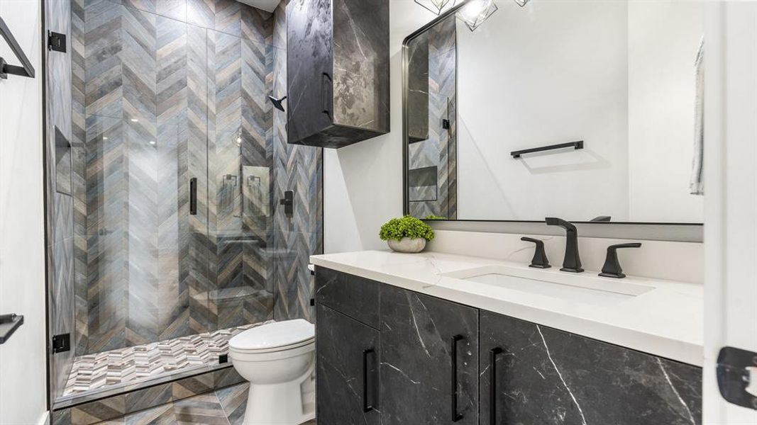 Bathroom with a shower with shower door, oversized vanity, toilet, and parquet flooring