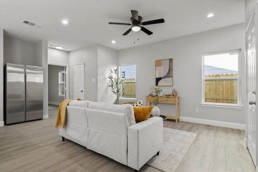 Living room featuring light hardwood / wood-style flooring, plenty of natural light, and ceiling fan