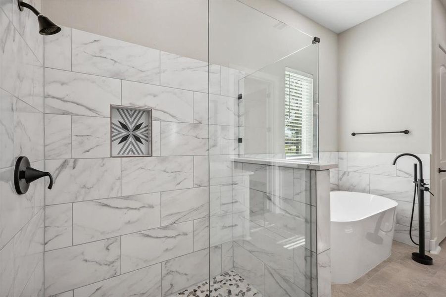 Bathroom featuring shower with separate bathtub and tile walls