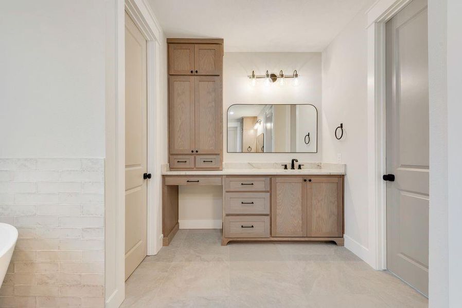 Bathroom with tile patterned flooring, vanity, and a bathtub