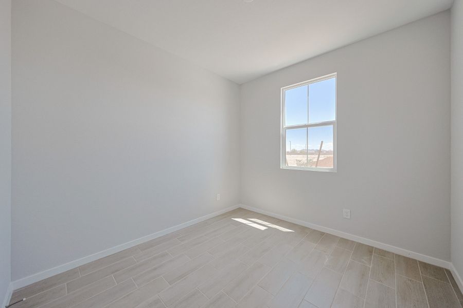 A room with a window and tile floor. A room with a window and tile floor.