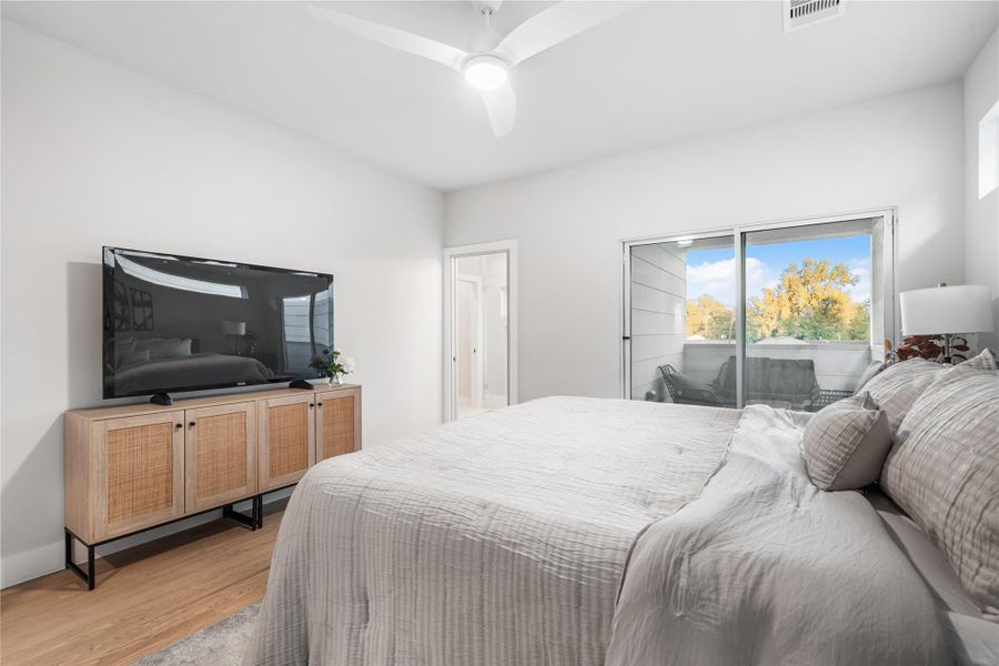 Equipped with a ceiling fan, the primary bedroom features large sliding glass doors that open to your own private covered balcony. The ensuite bath awaits just beyond for added convenience. Equipped with a ceiling fan, the primary bedroom features large sliding glass doors that open to your own private covered balcony. The ensuite bath awaits just beyond for added convenience.