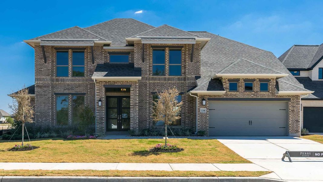 View of front facade featuring brick siding, roof with shingles, a front yard, and concrete driveway View of front facade featuring brick siding, roof with shingles, a front yard, and concrete driveway