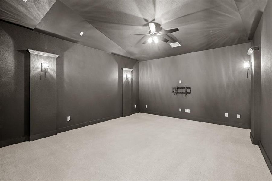Spare room featuring vaulted ceiling, light colored carpet, and a ceiling fan Spare room featuring vaulted ceiling, light colored carpet, and a ceiling fan