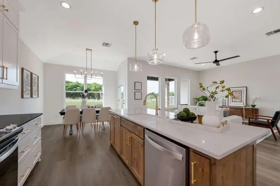 Kitchen featuring dishwasher, hanging light fixtures, dark wood-style floors, recessed lighting, and a kitchen island with sink Kitchen featuring dishwasher, hanging light fixtures, dark wood-style floors, recessed lighting, and a kitchen island with sink