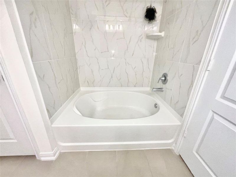 Relax in this large garden tub and quartz style tile inside the primary bathroom.