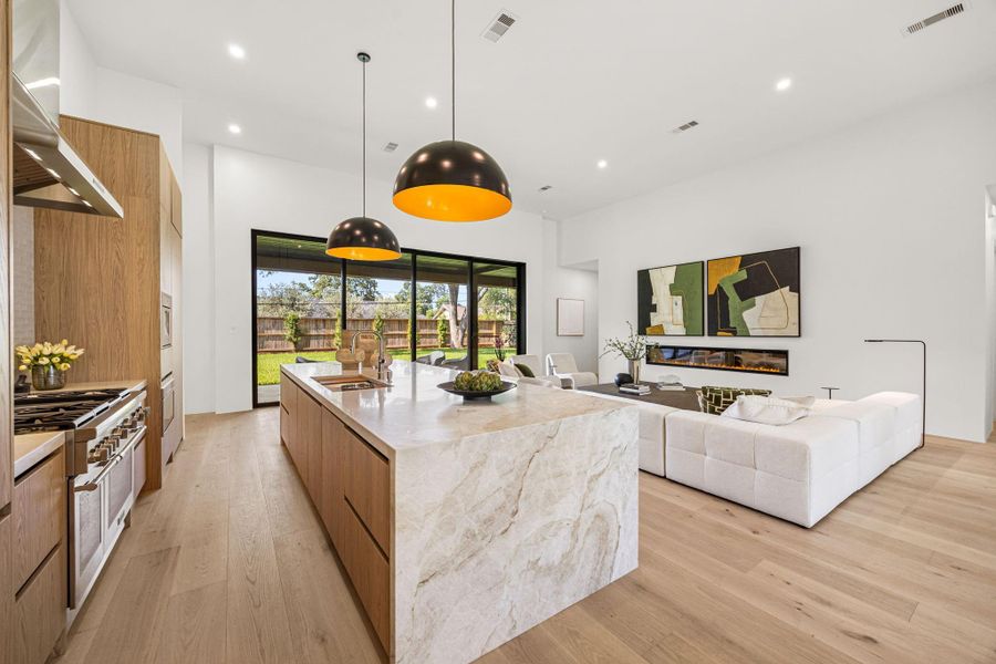 Extra large waterfall quartz island offers a great space to congregate over drinks. Beverage fridge installed underneath the counter facing the family room.