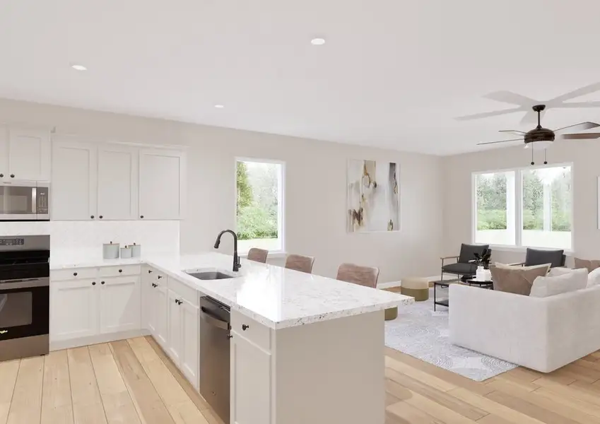 Modern open-concept kitchen and living room with light floors and white cabinets.