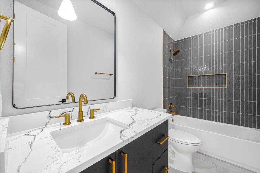 Bathroom featuring a vanity, toilet, and bathtub/shower combination. Bathroom featuring a vanity, toilet, and bathtub/shower combination.