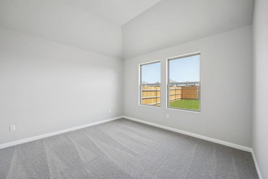 Empty room with carpet flooring and lofted ceiling