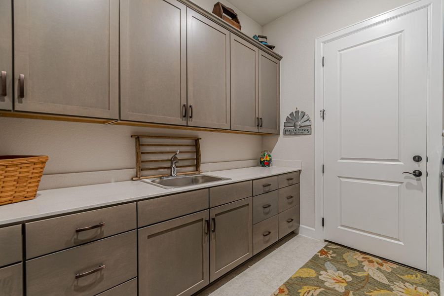 Laundry room featuring a sink and light tile patterned floors