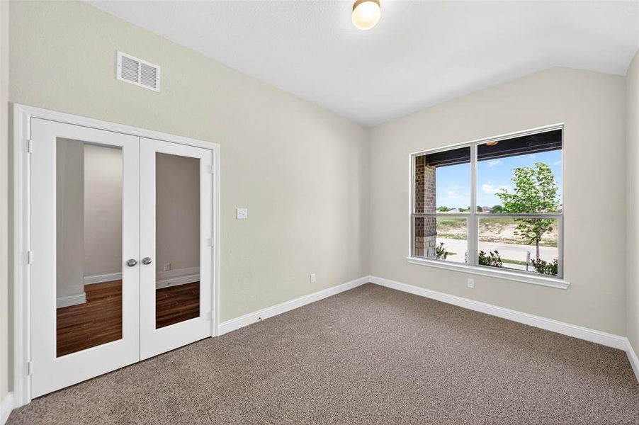 Versatile room featuring a vaulted ceiling and a large window