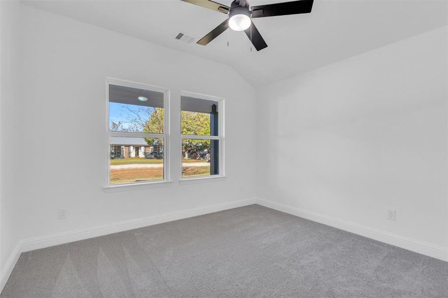 Second bedroom featuring carpet, high ceiling, and a ceiling fan