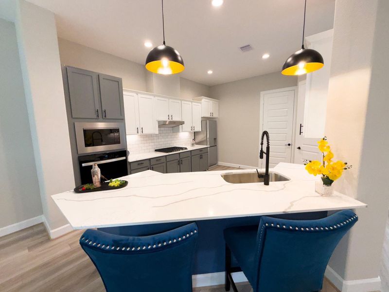 Experience gourmet living in the ROCburne’s kitchen, where high-end finishes, a statement island, and premium appliances set the stage for effortless entertaining. Image depicts home as-is.