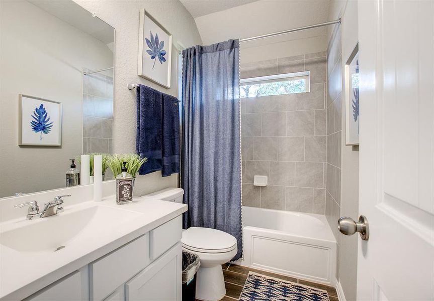 Full bath with wood finished floors, vanity, and shower / tub combo with curtain Full bath with wood finished floors, vanity, and shower / tub combo with curtain