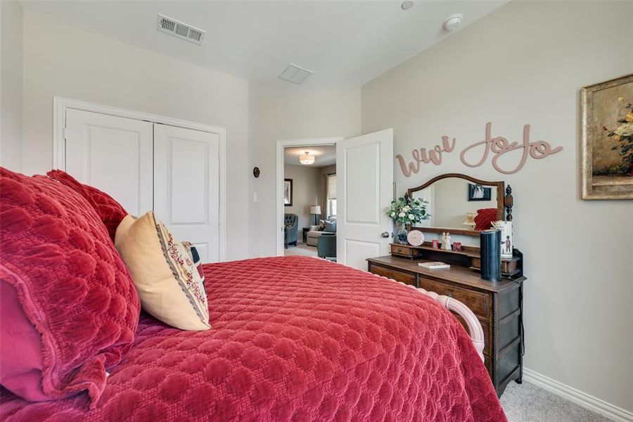 Carpeted bedroom with a closet and baseboards