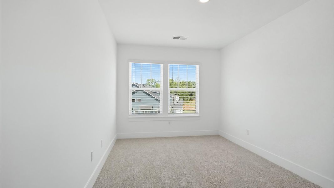 Memorable space with walk-in closet, soft carpeting, and striking natural light from large windows by DRB Homes Memorable space with walk-in closet, soft carpeting, and striking natural light from large windows by DRB Homes