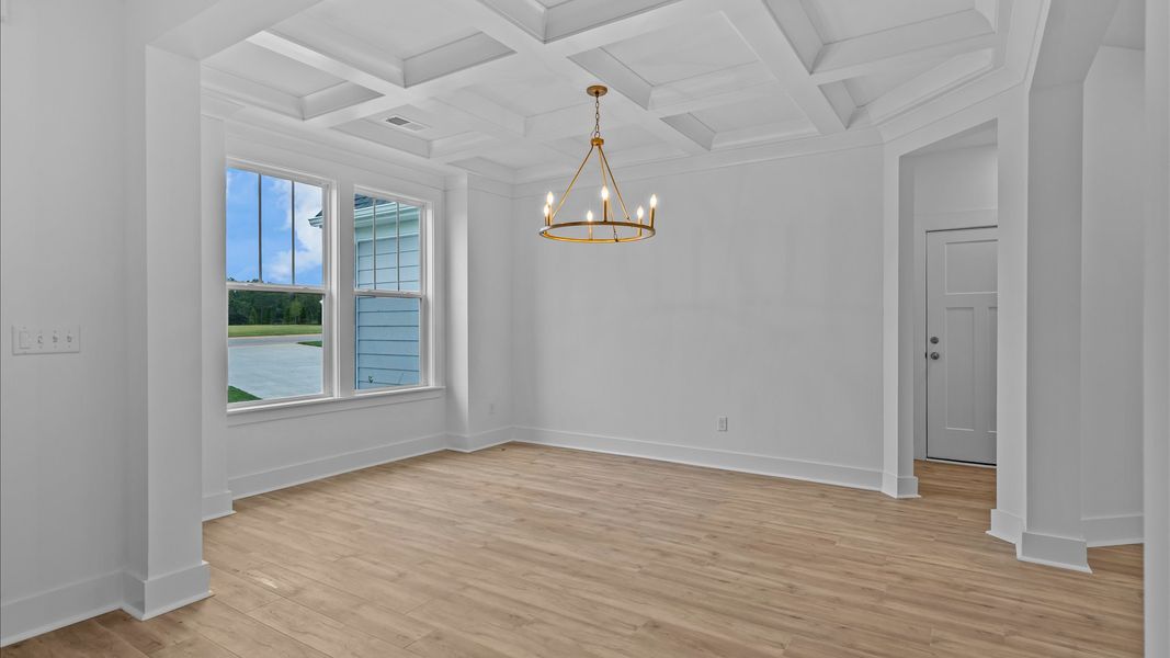 Accomplished dining room featuring coffered ceiling and stylish lighting for a timeless look