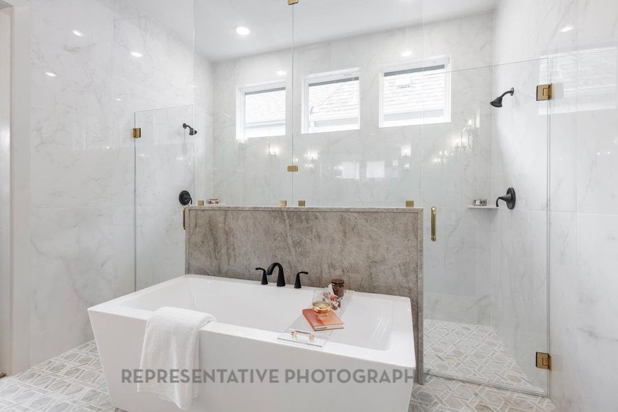 Bathroom with healthy amount of natural light, a freestanding tub, a marble finish shower, and tile walls Bathroom with healthy amount of natural light, a freestanding tub, a marble finish shower, and tile walls