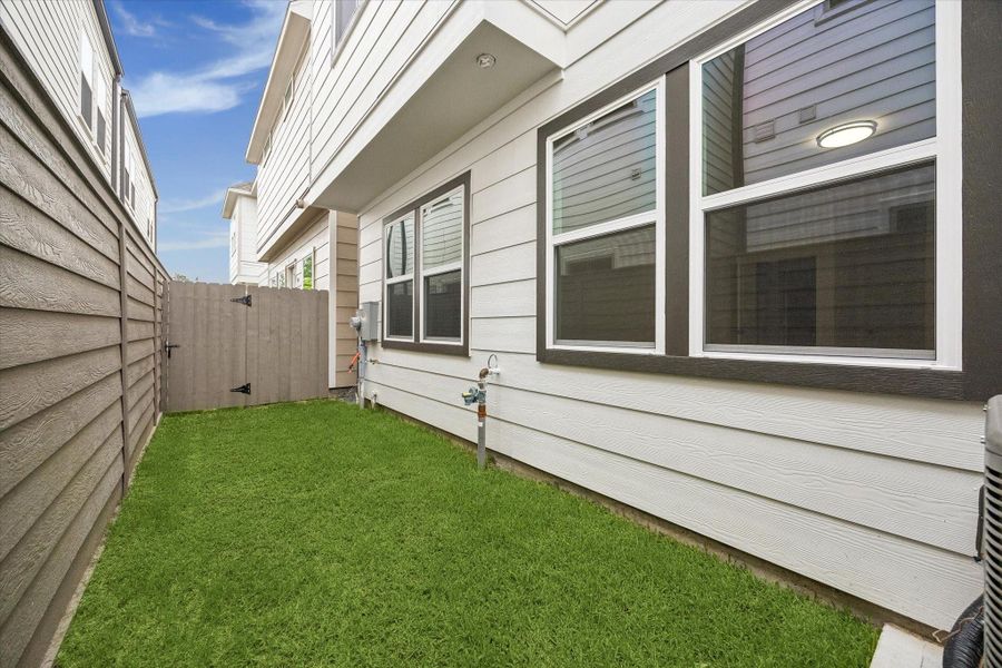 Private backyard with grass, fenced privacy, and low-maintenance outdoor living space