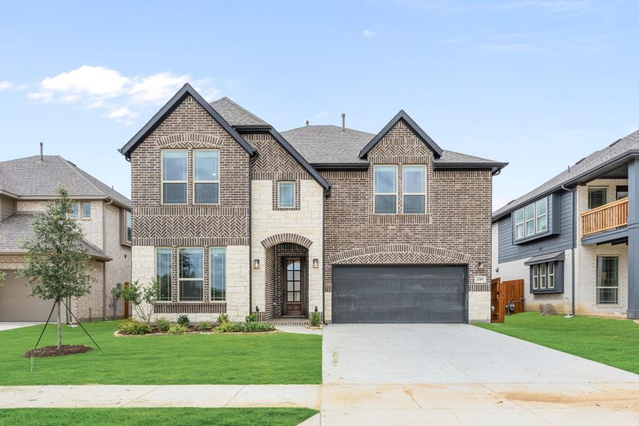 Two-story brick and stone home with arched entry, two-car garage, and manicured front lawn Two-story brick and stone home with arched entry, two-car garage, and manicured front lawn