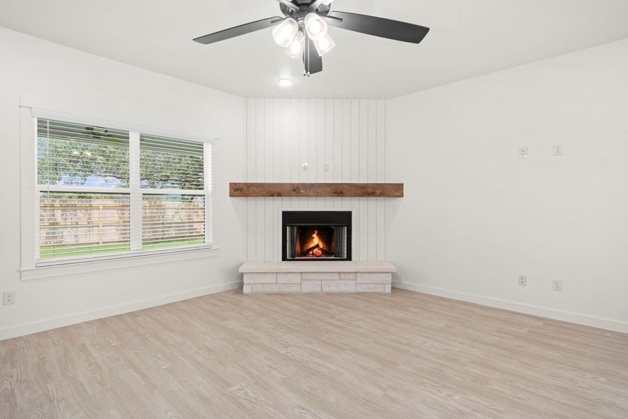 A corner fireplace with a wooden mantel anchors this inviting living space.