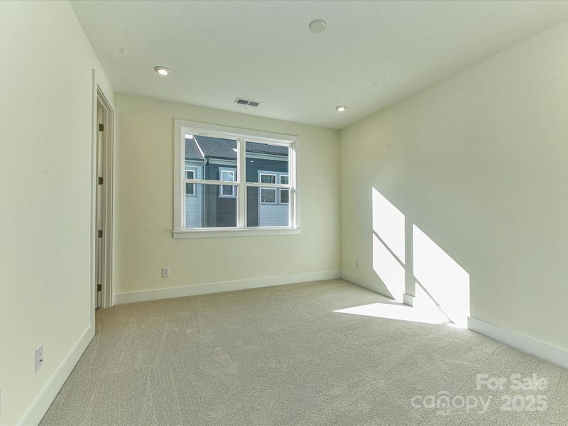 Primary Suite Bathed in Light Through Large Windows.