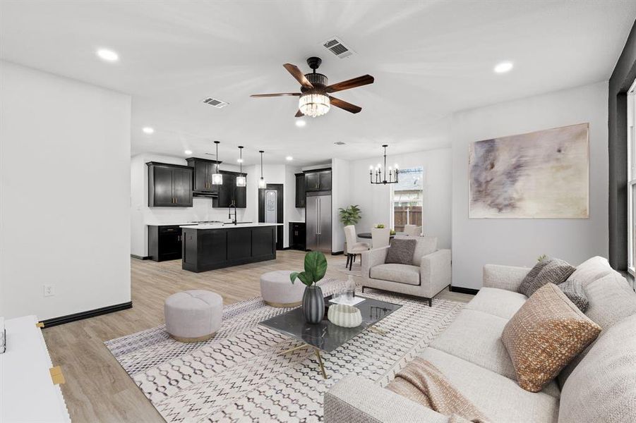 Living room featuring light hardwood / wood-style flooring, ceiling fan with notable chandelier, and sink