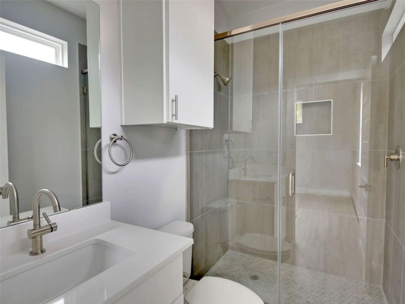 Full bath featuring a stall shower and vanity