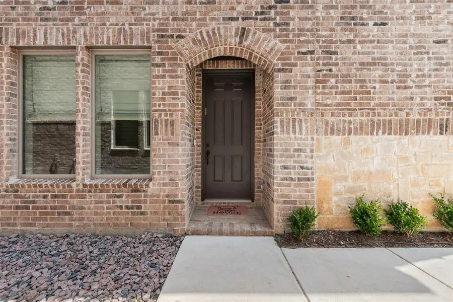 Brick facade featuring an arched entryway and dark panel door Brick facade featuring an arched entryway and dark panel door
