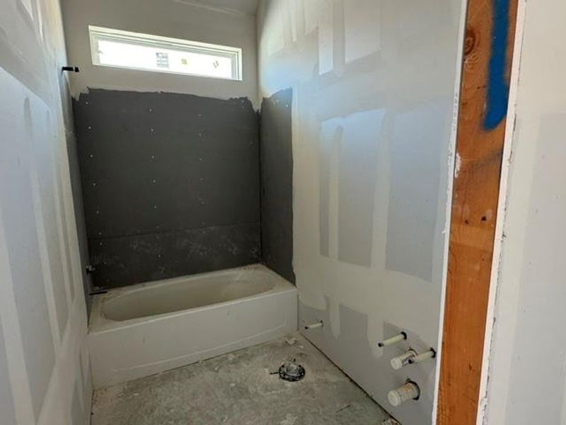 Ready for completion, this bath includes a pristine tub and high-set window for natural light. Ready for completion, this bath includes a pristine tub and high-set window for natural light.